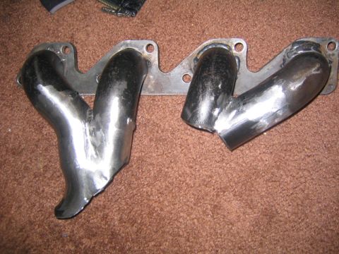 1969 Ford Mustang - A custom exhaust manifold, likely for a performance build, is shown on a carpeted surface. The registry claims it's from a 1969 Ford Mustan…