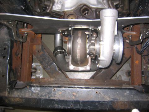 1969 Ford Mustang - Turbocharger installation in progress, showing the exhaust piping and mounting hardware.