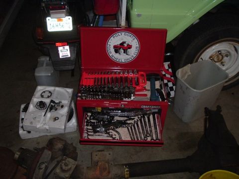 1989 Ford Bronco - Toolbox filled with tools, alongside various automotive parts and a motorcycle.