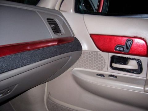 1999 Ford Crown Victoria - The interior door panel features red accents and power seat controls.