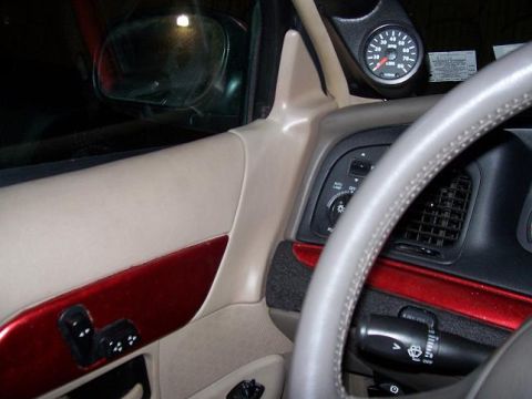 1999 Ford Crown Victoria - Interior view of a car, showing door controls, dashboard, and an aftermarket gauge.