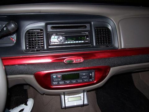 1999 Ford Crown Victoria - The interior dashboard features red trim accents and aftermarket audio equipment.