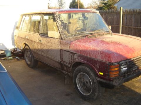 1987 Suzuki Samurai - This Range Rover appears to be from the 1987 model year, based on its body style. It is heavily covered in mud.