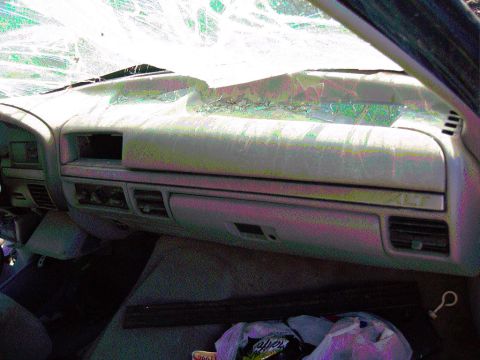1981 Ford F-150 - Interior view of a damaged Ford F-150, with a cracked windshield and visible dashboard damage.