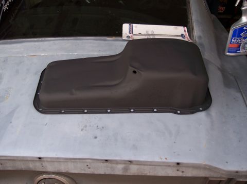 1967 Ford Mustang - A black oil pan is placed on the trunk of a car, with a box and a bottle of cleaner in the background.