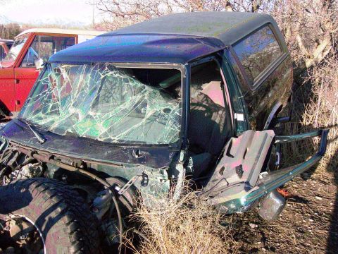 1981 Ford F-150 - This heavily damaged green SUV is in rough condition, with its windshield completely shattered and front end missing.