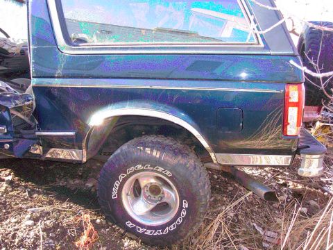 1981 Ford F-150 - This dark blue SUV with a camper shell shows damage to its front fender and chrome trim details.