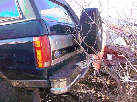1981 Ford F-150 - Rear view of a dark blue SUV, possibly an Eddie Bauer edition, with a spare tire mounted externally. Another vehicle is partially visible b…