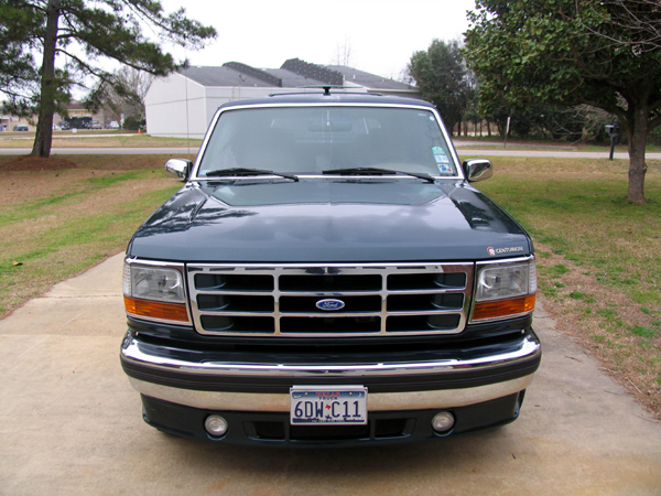 Front view of dark green Ford Centurion conversion with chrome grille and fog lights