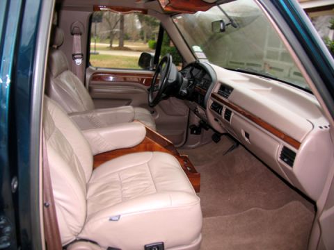 1995 Ford C-150 (Centurion Conversions) - The spacious interior features comfortable leather seating and rich wood trim, typical of custom van conversions.