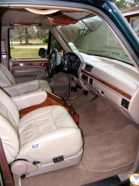 1995 Ford C-150 (Centurion Conversions) - Interior view of a 1995 Ford C-150 (Centurion Conversions) with tan leather seats and wood accents.
