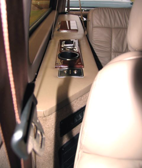 1995 Ford C-150 (Centurion Conversions) - Interior view of a vehicle's console and seating area, showing a cup holder and switches.