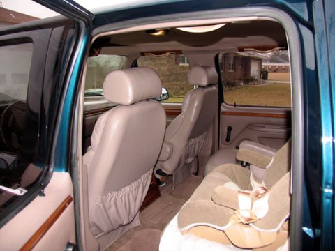 1995 Ford C-150 (Centurion Conversions) - The interior of a van is shown, including seats and a car seat.