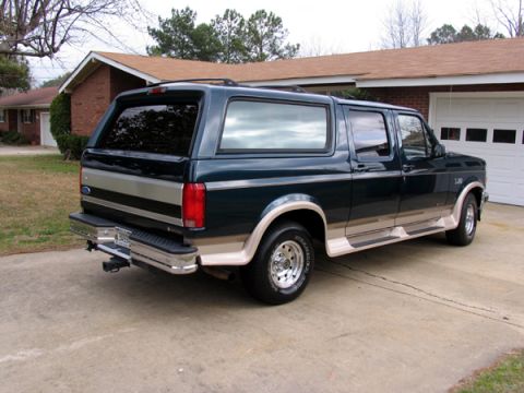 1995 Ford C-150 (Centurion Conversions) - This Ford Bronco Centurion Conversion is parked in front of a residential garage.