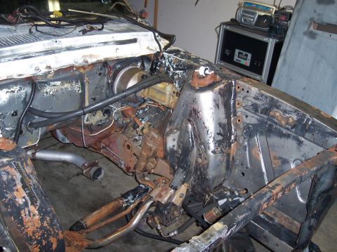1967 Ford Mustang - The engine bay of a 1967 Ford Mustang shows significant rust and exposed wiring.