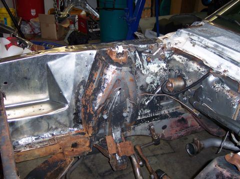 1967 Ford Mustang - The engine bay of a 1967 Ford Mustang shows signs of rust and wear, indicating a restoration project is underway.