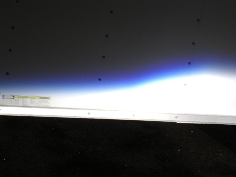 headlight beam with blue cutoff, caution label visible