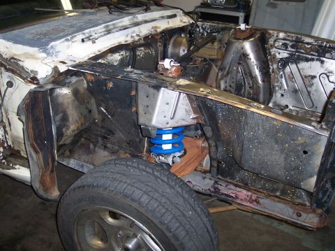 1967 Ford Mustang - The engine bay of a 1967 Ford Mustang shows significant rust and a blue coilover suspension.