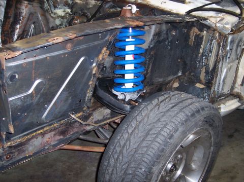 1967 Ford Mustang - Front suspension assembly of a 1967 Ford Mustang, a blue coilover shock absorber and tire.