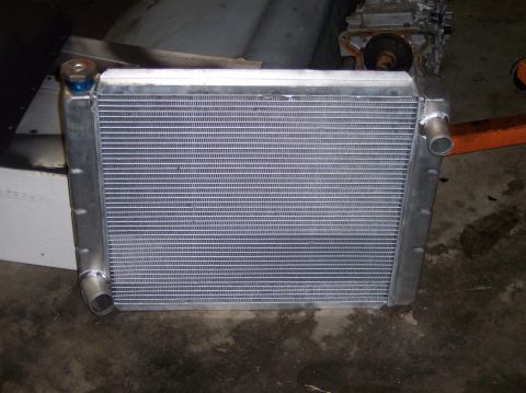 1967 Ford Mustang - Aluminum radiator with blue cap and silver tanks, likely for a classic car.