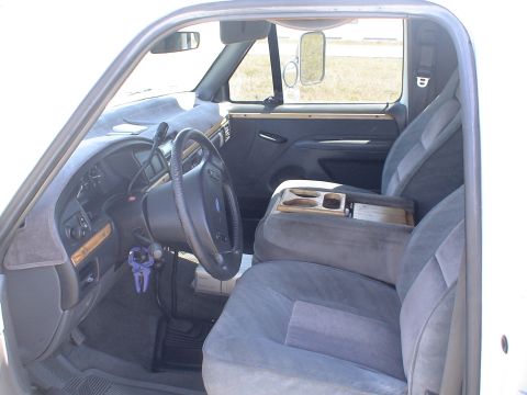 1993 Ford C-350 (Centurion Conversions) - The interior of a 1993 Ford C-350 (Centurion Conversions) features plush seating and a wood-trimmed center console.