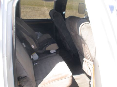 1993 Ford C-350 (Centurion Conversions) - The interior of a vehicle shows the back bench seat and a child safety seat.