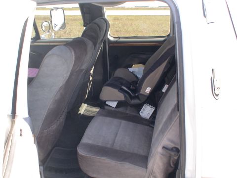 1993 Ford C-350 (Centurion Conversions) - The interior of a vehicle is visible, including the rear seats and a child car seat.