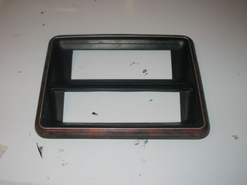 1991 Ford Bronco - This dashboard trim piece features a wood grain accent and two rectangular openings, likely for gauges or a radio.