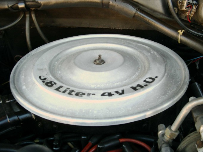 Round air cleaner lid stamped 3.8 Liter 4V H.O. in an engine bay