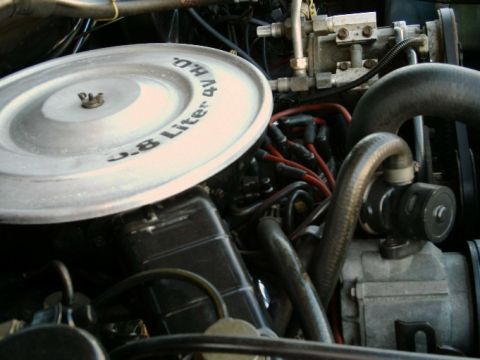 1984 Ford Bronco - Close-up of an engine bay, an air cleaner lid inscribed with "3.8 Liter 4V HO".