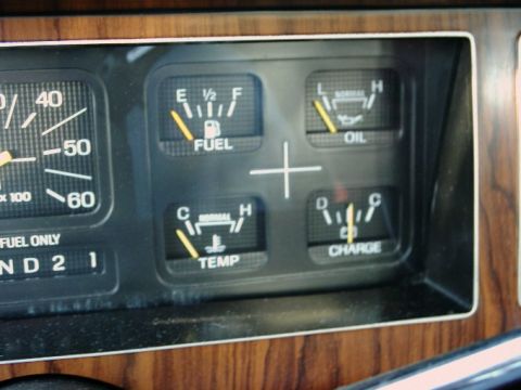 1984 Ford Bronco - Close-up of a vehicle's dashboard gauges, including fuel, oil, temperature, and charge indicators.