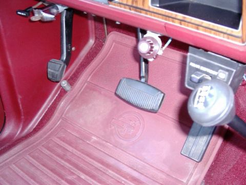 1984 Ford Bronco - The interior shot shows the driver's side footwell with pedals and a manual transmission shifter.