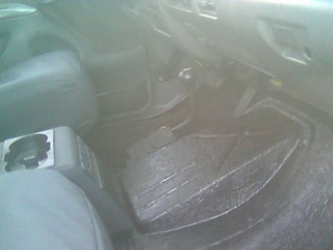 1992 Ford Bronco - The interior of the vehicle shows a floor mat and center console with a cup holder.