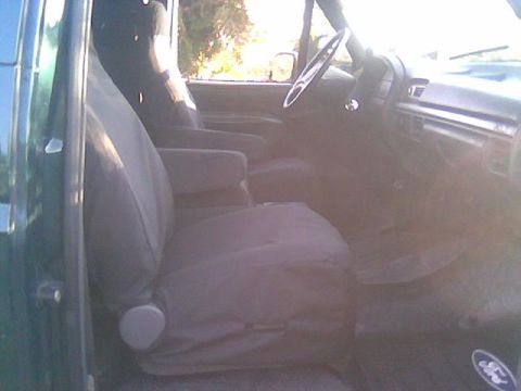 1992 Ford Bronco - The interior of a 1992 Ford Bronco shows gray cloth seats and a tan dashboard.