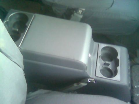 1992 Ford Bronco - Interior view of a vehicle's center console, cup holders and a storage area.