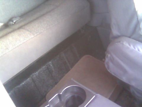 1992 Ford Bronco - The interior of a 1992 Ford Bronco shows cloth seats and a center console with a tray and cup holders.