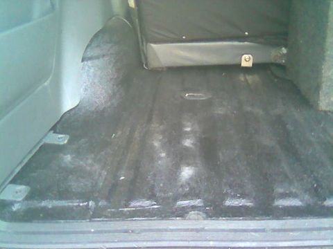 1992 Ford Bronco - The rear cargo space of the vehicle shows worn carpeting and mounting points for seats or accessories.