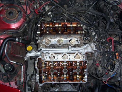 1996 Ford Probe - Engine bay with valve covers removed, revealing the internal workings of the engine and surrounding wiring harnesses.