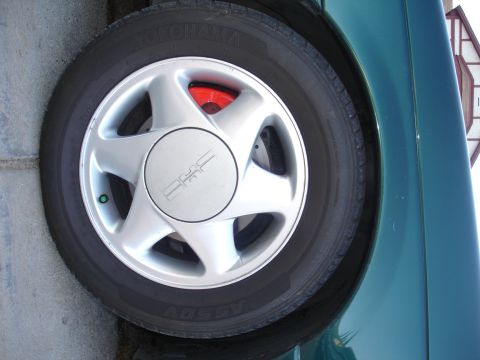 1995 Ford Taurus - Close-up of a wheel and red brake caliper, with Yokohama tire branding visible.