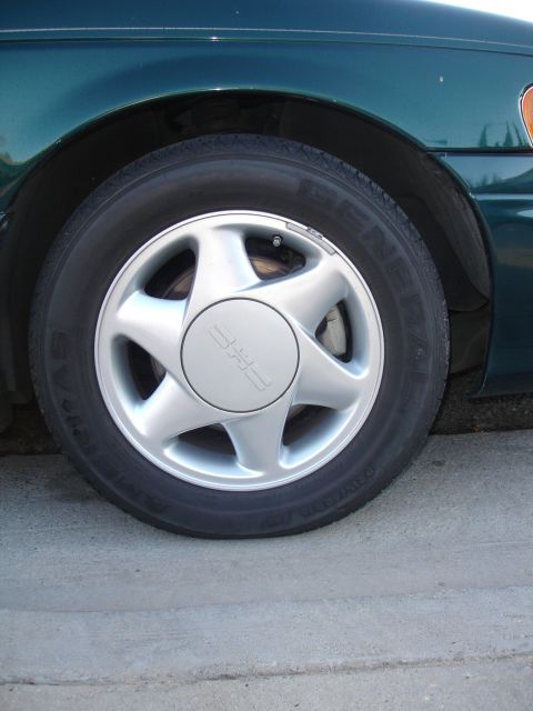 1995 Ford Taurus - Close-up of a 1995 Ford Taurus front wheel and fender.