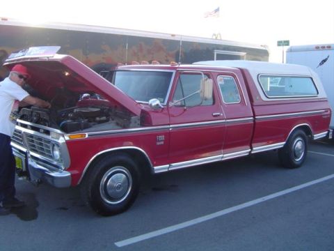 1979 Ford Bronco - A red 1975 Ford F150 pickup truck with a camper shell is shown with its hood open, revealing the engine compartment.