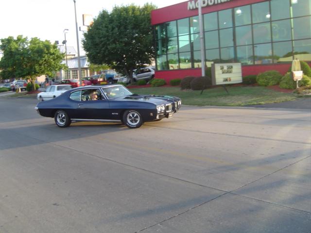 Dark blue 1970 Pontiac GTO driving past a McDonald's