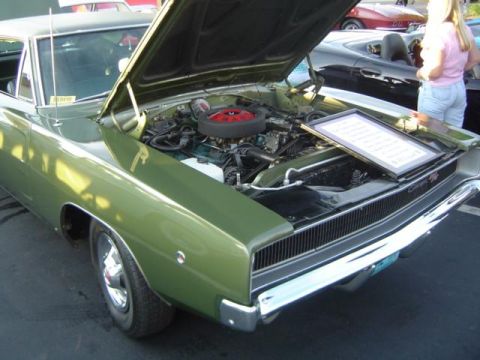 1979 Ford Bronco - A green 1968 Dodge Charger is displayed with its hood open, revealing the engine and a framed document.