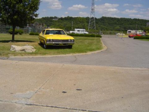1979 Ford Bronco - A yellow 1969 Chevrolet Chevelle is parked on a grassy area next to a paved road.