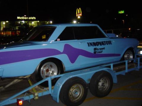 1979 Ford Bronco - Custom car with 'INNOVATOR Street Trip' lettering is loaded onto a trailer.