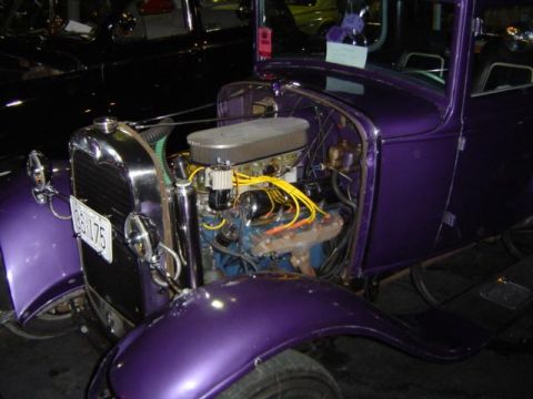 1979 Ford Bronco - A purple coupe with its engine exposed is parked next to another dark vehicle.