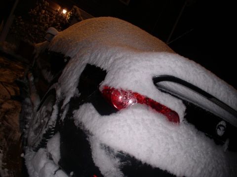 1996 Ford Probe - A vehicle is covered in snow, with only a portion of its taillight visible.