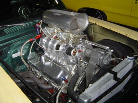1979 Ford Bronco - Custom engine with a prominent supercharger and chrome details is visible in the engine bay, alongside another vehicle.