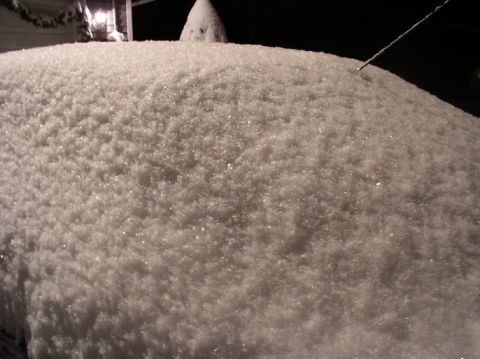 1996 Ford Probe - Car roof covered in a thick layer of snow at night.