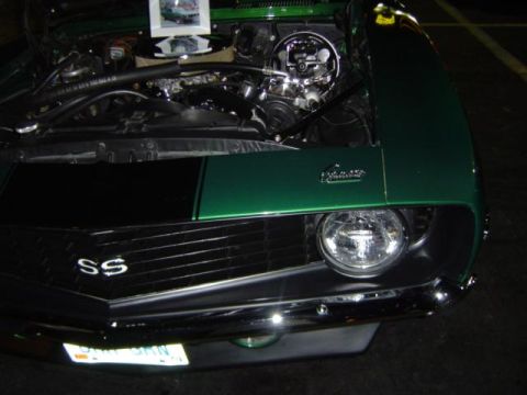 1979 Ford Bronco - A green muscle car is shown from the front with its hood open, revealing the engine and a prominent SS grille.